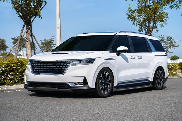 White Kia Carnival parked on street